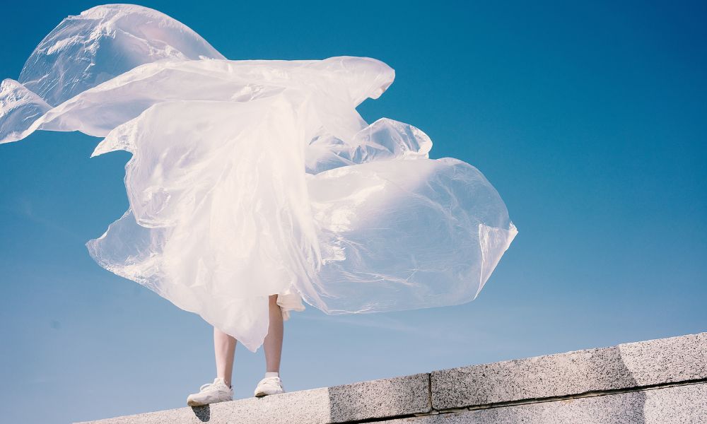 Redding Associates - image of person standing on wal, with white plastic bag blowing in front of them